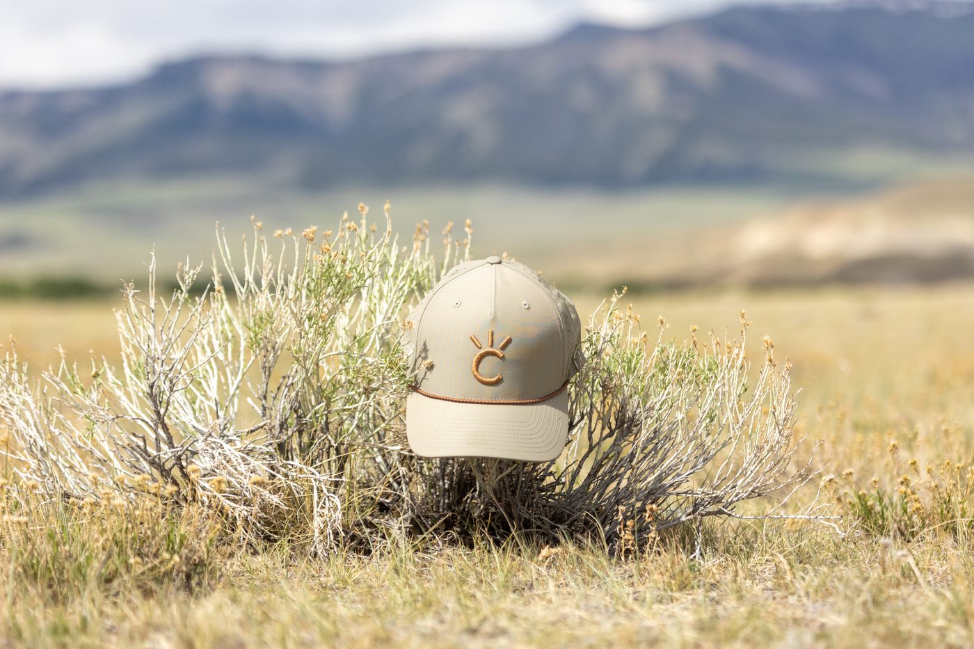 The Buckskin Cap, a tan Cavvy performance rope hat photographed in an open field